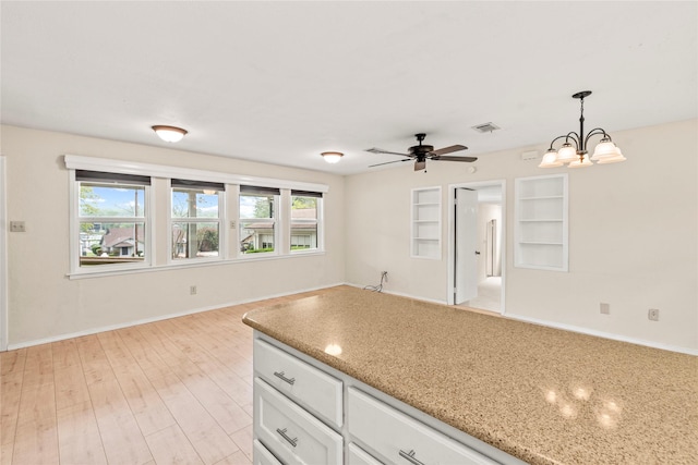kitchen featuring hanging light fixtures, a wealth of natural light, light wood finished floors, and visible vents