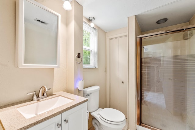 bathroom featuring toilet, vanity, a shower stall, and visible vents