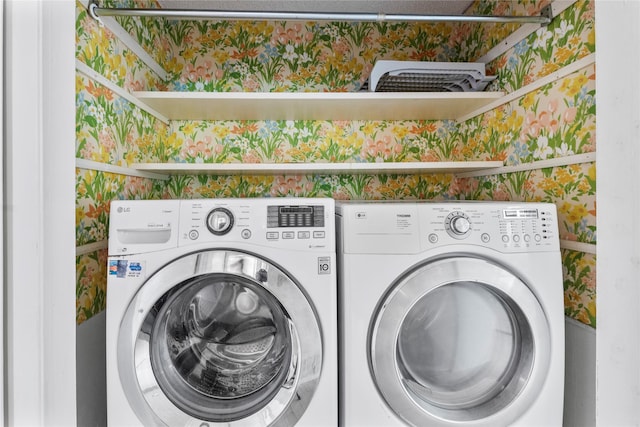 washroom with wallpapered walls, washing machine and dryer, and laundry area