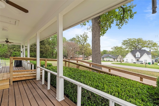 wooden terrace with a residential view, a porch, and ceiling fan