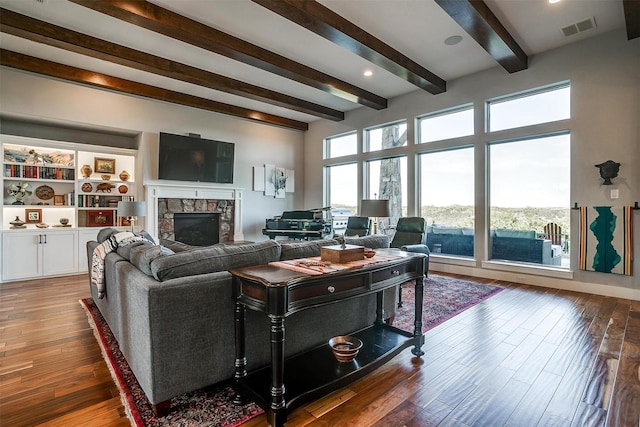 8225 Scotscraig Ct, Cleburne, TX 76033 - living area with beamed ceiling, a stone fireplace, and wood-type flooring