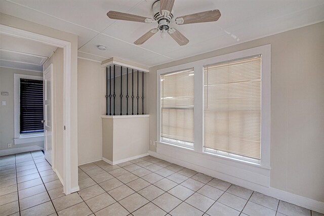 unfurnished room featuring a ceiling fan, light tile patterned floors, and baseboards