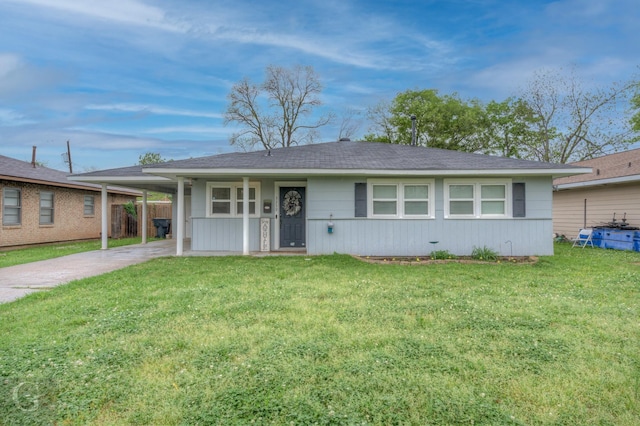 ranch-style house featuring an attached carport, a front yard, driveway, and roof with shingles