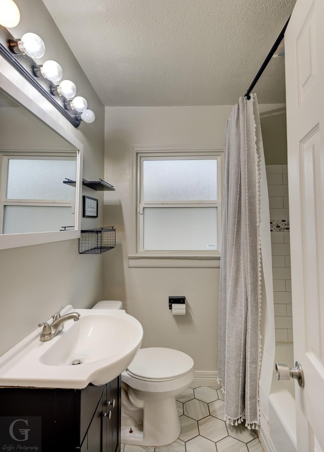 full bath featuring a textured ceiling, toilet, vanity, shower / bath combination with curtain, and tile patterned flooring
