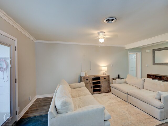 living room featuring crown molding, a ceiling fan, wood finished floors, baseboards, and visible vents