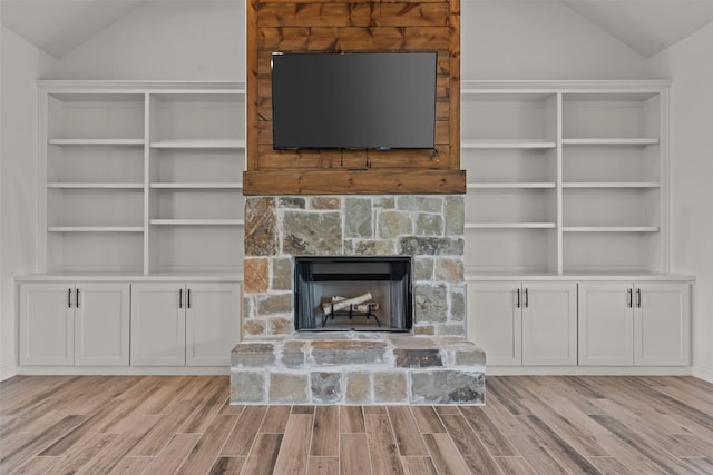 2017 Antler Loop, Poolville, TX 76487 - unfurnished living room featuring a stone fireplace, wood finished floors, and vaulted ceiling