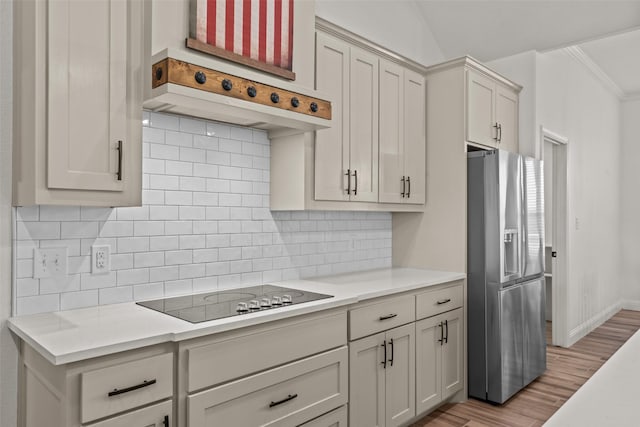 2017 Antler Loop, Poolville, TX 76487 - kitchen with decorative backsplash, stainless steel refrigerator with ice dispenser, light countertops, black electric stovetop, and light wood-style floors