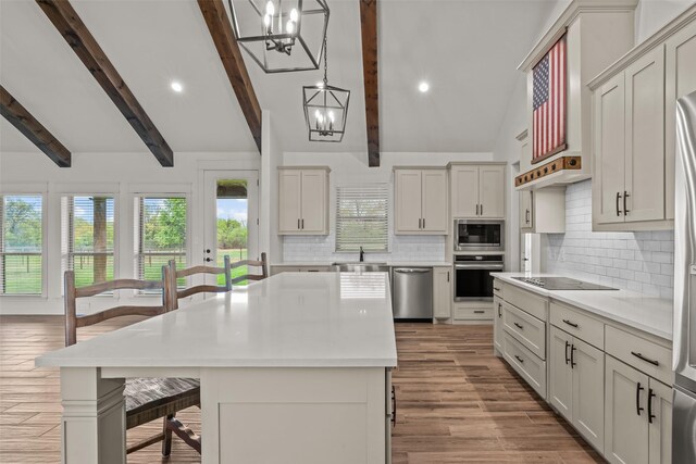2017 Antler Loop, Poolville, TX 76487 - kitchen featuring a kitchen breakfast bar, light countertops, a notable chandelier, vaulted ceiling with beams, and stainless steel appliances