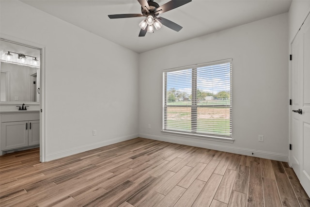 2017 Antler Loop, Poolville, TX 76487 - unfurnished bedroom featuring baseboards, a sink, light wood-style flooring, and ensuite bath