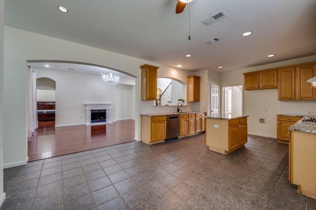 kitchen featuring open floor plan, visible vents, ceiling fan with notable chandelier, and dishwasher