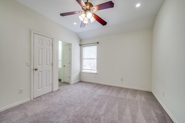 unfurnished bedroom featuring carpet flooring, baseboards, and vaulted ceiling