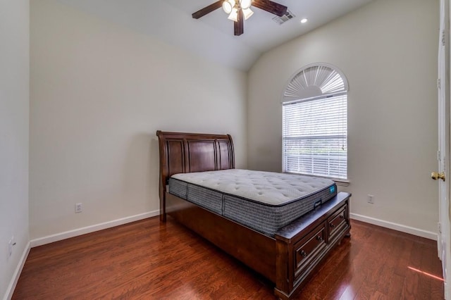 bedroom with baseboards, visible vents, vaulted ceiling, and wood finished floors