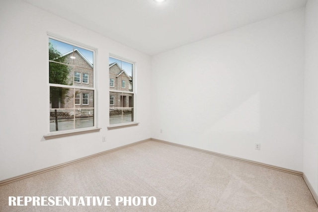 unfurnished room featuring carpet flooring and baseboards
