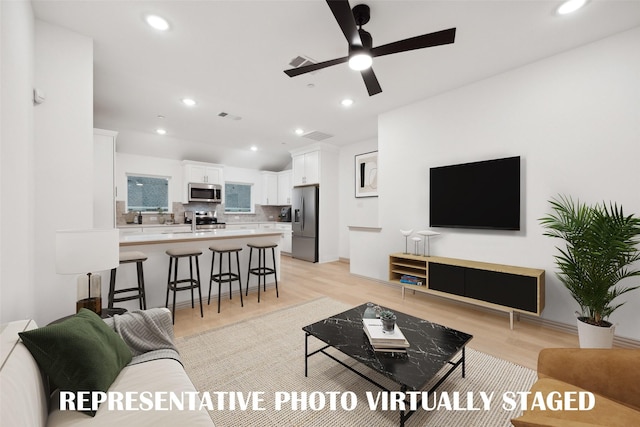 living area featuring recessed lighting, light wood finished floors, visible vents, and ceiling fan