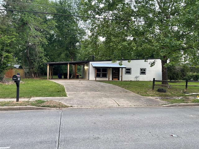 mid-century modern home with a carport, a front yard, and concrete driveway