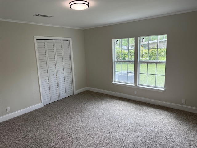 unfurnished bedroom with baseboards, carpet, ornamental molding, and multiple windows