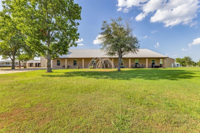 view of front of home featuring a front lawn and metal roof