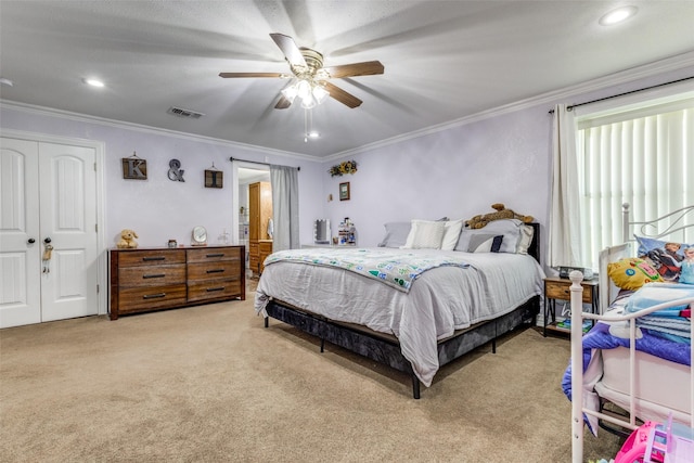 bedroom featuring a closet, light carpet, crown molding, a ceiling fan, and visible vents