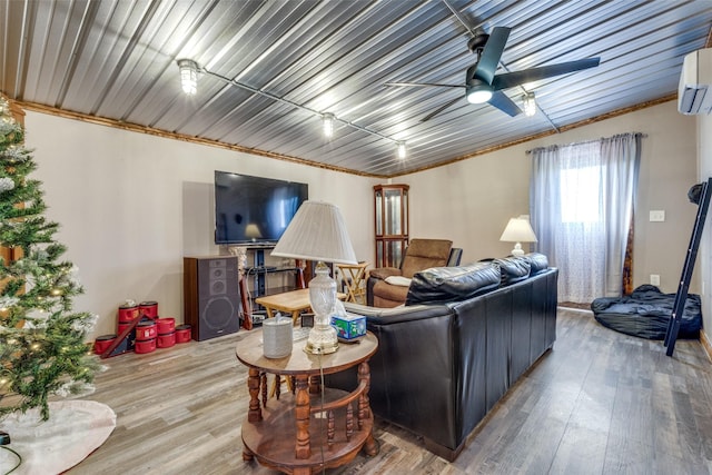 living room featuring an AC wall unit, a ceiling fan, and wood finished floors