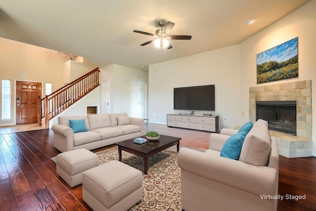 living area featuring hardwood / wood-style flooring, stairs, ceiling fan, and a fireplace