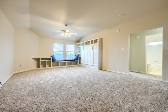 unfurnished bedroom with carpet, lofted ceiling, baseboards, and ceiling fan