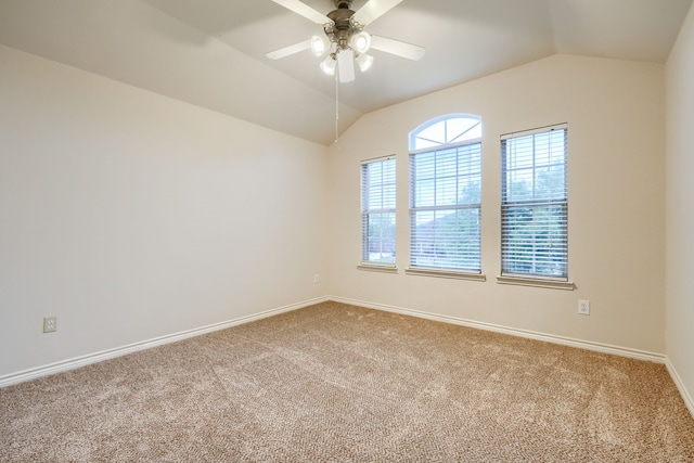 empty room featuring carpet floors, lofted ceiling, a ceiling fan, and baseboards