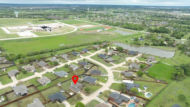 aerial view of property's location featuring a nearby body of water and nearby suburban area