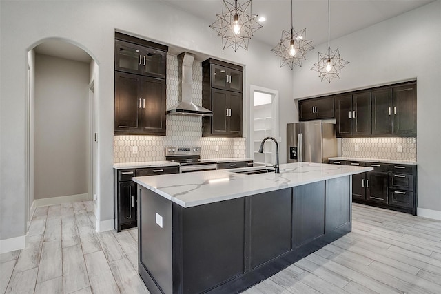 521 Echo Glade Ct, Azle, TX 76020 - kitchen with wall chimney range hood, appliances with stainless steel finishes, a sink, arched walkways, and tasteful backsplash