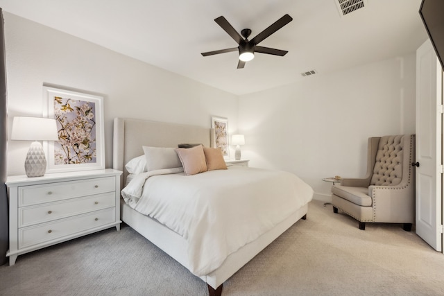 bedroom featuring visible vents, a ceiling fan, and light carpet