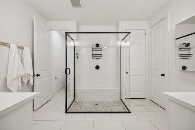 full bath featuring vanity, tile patterned flooring, a shower stall, and visible vents