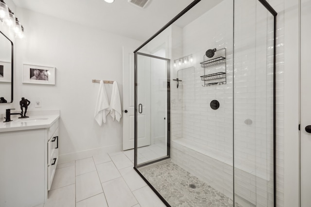 bathroom featuring tile patterned flooring, vanity, visible vents, baseboards, and a shower stall