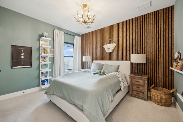 carpeted bedroom with a chandelier, baseboards, and visible vents