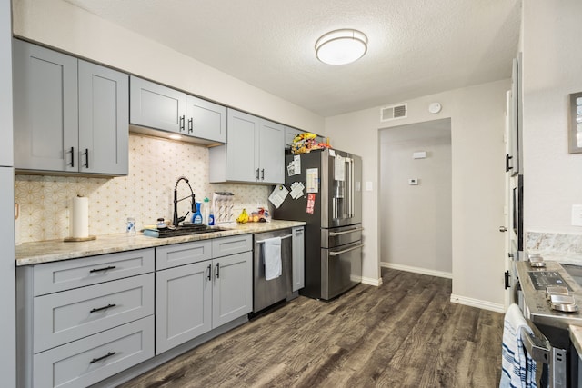 201 Volunteer Dr, Arlington, TX 76014 - kitchen featuring visible vents, a sink, dark wood-style flooring, appliances with stainless steel finishes, and gray cabinetry