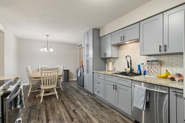 201 Volunteer Dr, Arlington, TX 76014 - kitchen featuring dark wood-style flooring, a sink, stainless steel appliances, decorative backsplash, and gray cabinetry