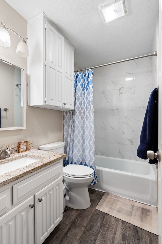 201 Volunteer Dr, Arlington, TX 76014 - bathroom featuring shower / bath combo, toilet, a textured ceiling, vanity, and wood finished floors