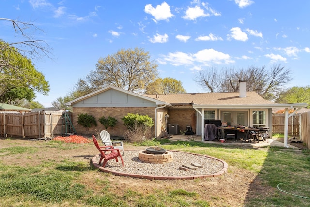 201 Volunteer Dr, Arlington, TX 76014 - rear view of house featuring a fenced backyard, an outdoor fire pit, a patio, brick siding, and central AC unit