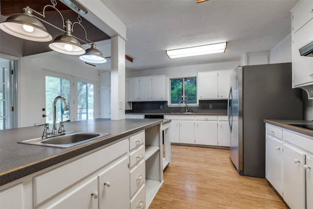 7219 Hickey Rd, Azle, TX 76020 - kitchen featuring dark countertops, a sink, white cabinetry, and light wood-style flooring