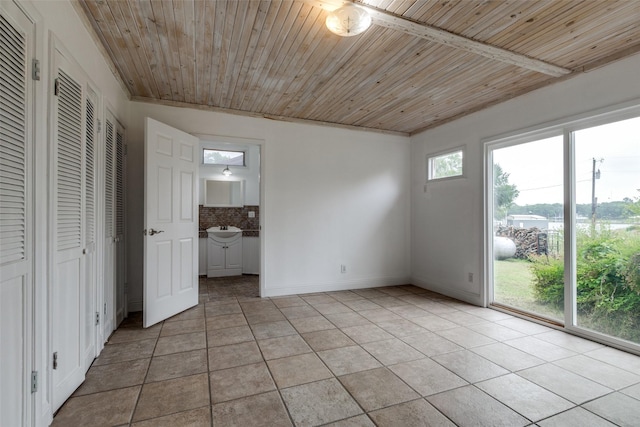 7219 Hickey Rd, Azle, TX 76020 - unfurnished bedroom with light tile patterned floors, wooden ceiling, access to exterior, a sink, and baseboards
