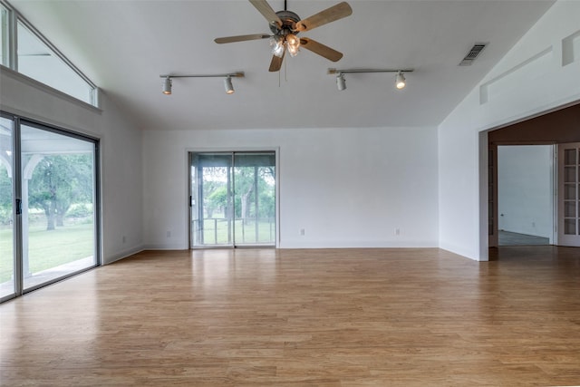 7219 Hickey Rd, Azle, TX 76020 - spare room featuring rail lighting, ceiling fan, light wood-style floors, baseboards, and high vaulted ceiling