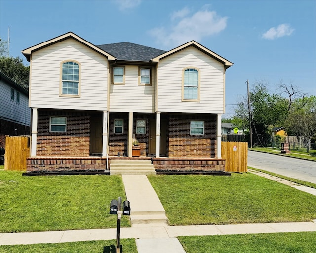 view of front of house featuring a porch, fence, brick siding, a front lawn, and roof with shingles