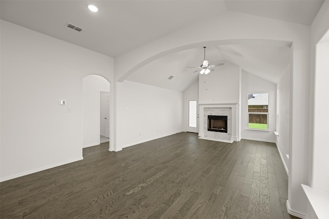 7745 Gatevine Ave, Joshua, TX 76058 - unfurnished living room with a ceiling fan, vaulted ceiling, dark wood-style flooring, arched walkways, and a fireplace