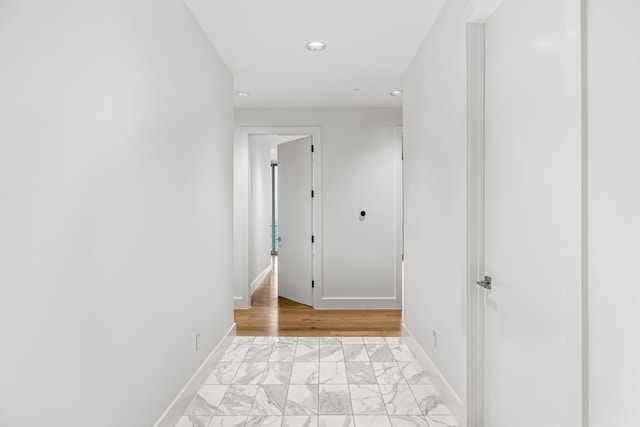 hallway with marble finish floor and baseboards