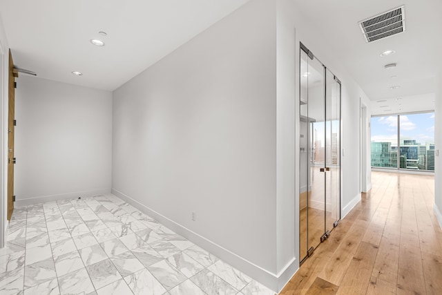 hallway with recessed lighting, baseboards, visible vents, and a barn door