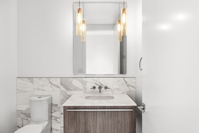 bathroom featuring toilet, marble finish floor, and vanity