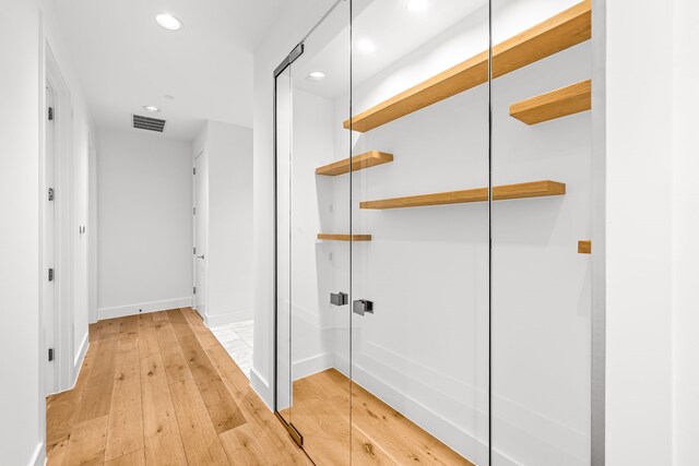 corridor with recessed lighting, light wood finished floors, visible vents, and baseboards