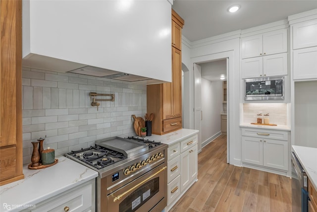 386 Newburn Ln, Shreveport, LA 71106 - kitchen with white cabinetry, wall chimney exhaust hood, backsplash, and appliances with stainless steel finishes