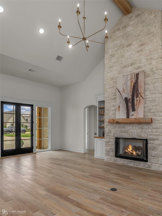 386 Newburn Ln, Shreveport, LA 71106 - unfurnished living room with arched walkways, beam ceiling, light wood-style flooring, and visible vents