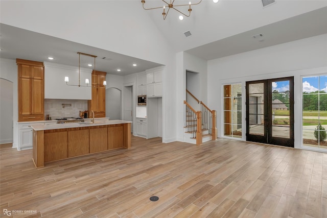 386 Newburn Ln, Shreveport, LA 71106 - kitchen featuring light wood finished floors, a sink, high vaulted ceiling, a notable chandelier, and light countertops
