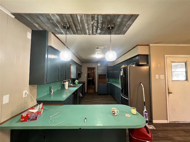 kitchen featuring dark wood-style floors, freestanding refrigerator, decorative light fixtures, visible vents, and a sink