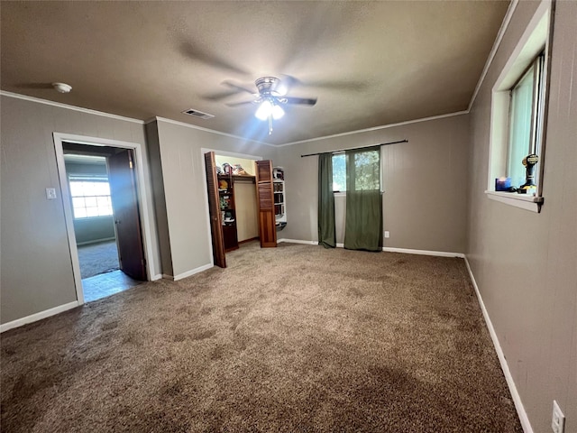 unfurnished bedroom with crown molding, multiple windows, and light carpet